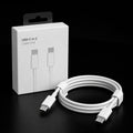 White USB-C to C cable with a coiled loop and white plastic ties, displayed next to its white retail packaging box on a black background.