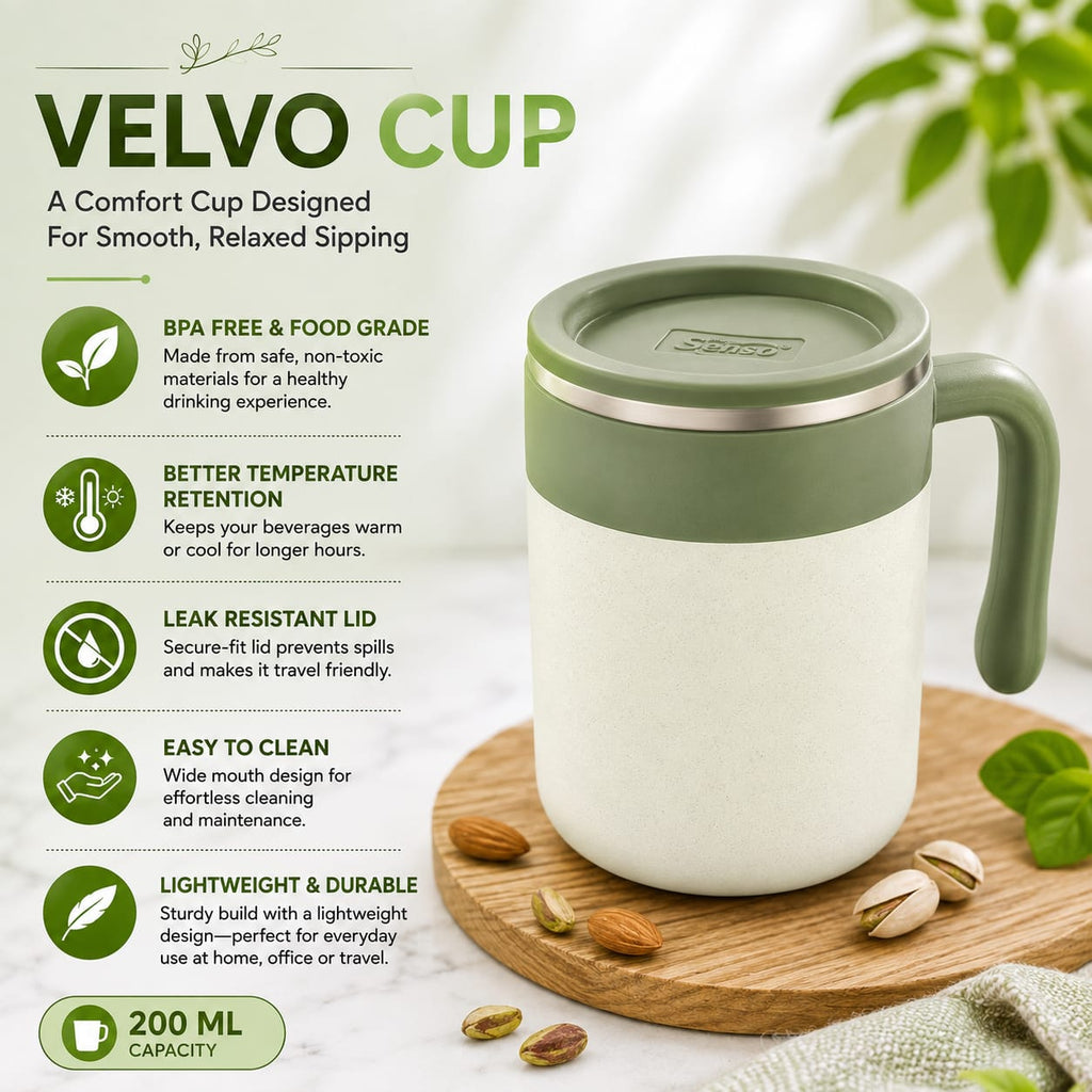 A VELVO CUP insulated travel mug with a light sage green lid and handle, shown on a wooden board with pistachios. The background is a soft, warm off-white with decorative green leaves, and the left side features a text panel detailing the mug's features: BPA free, better temperature retention, leak resistant lid, easy to clean, lightweight, and 200 ml capacity.