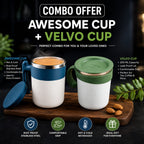 Two insulated travel mugs shown on a wooden tray in a promotional composite. The left mug is white with a blue handle and blue band, filled with an orange beverage; the right mug is white with a green handle and green lid.