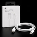 White Apple USB-C to Lightning cable shown next to its white retail box on a black background.